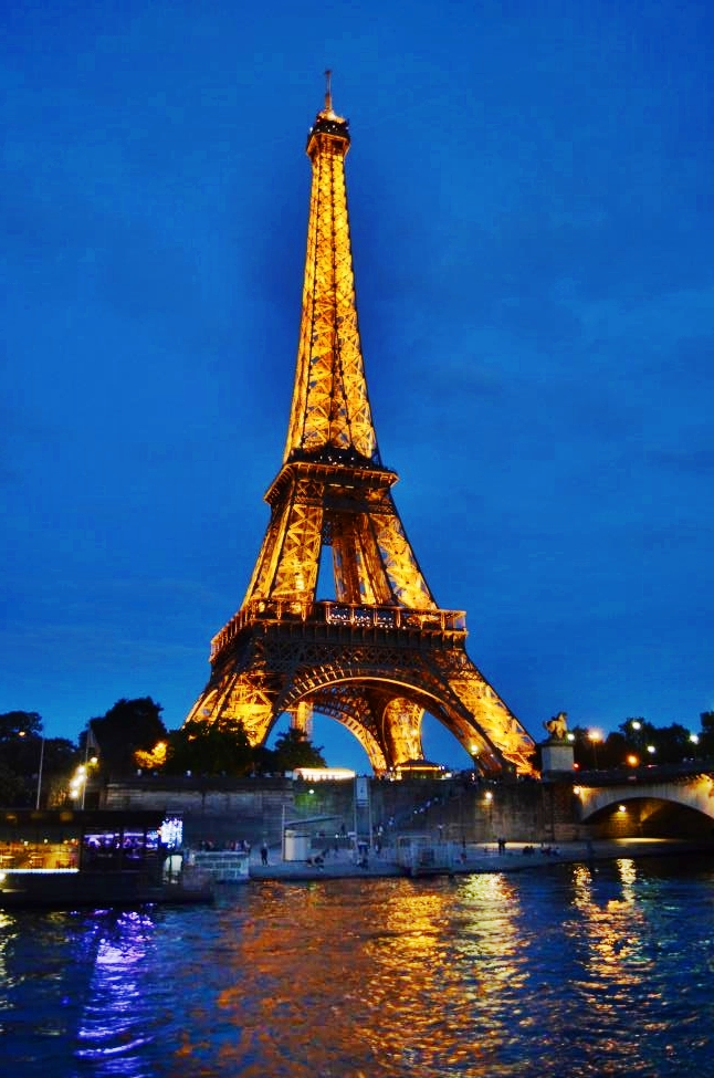 Eiffel Tower with evening lights, seen from Seine river boat