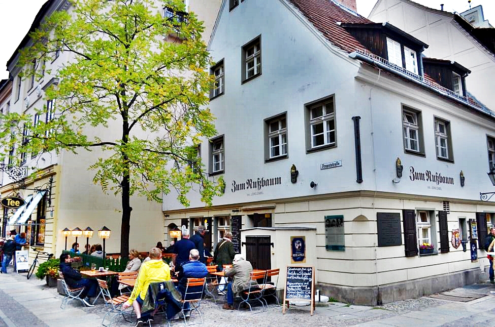 Zum Nussbaum iconic tavern in the center of Nikolaiviertel with people sitting in the garden