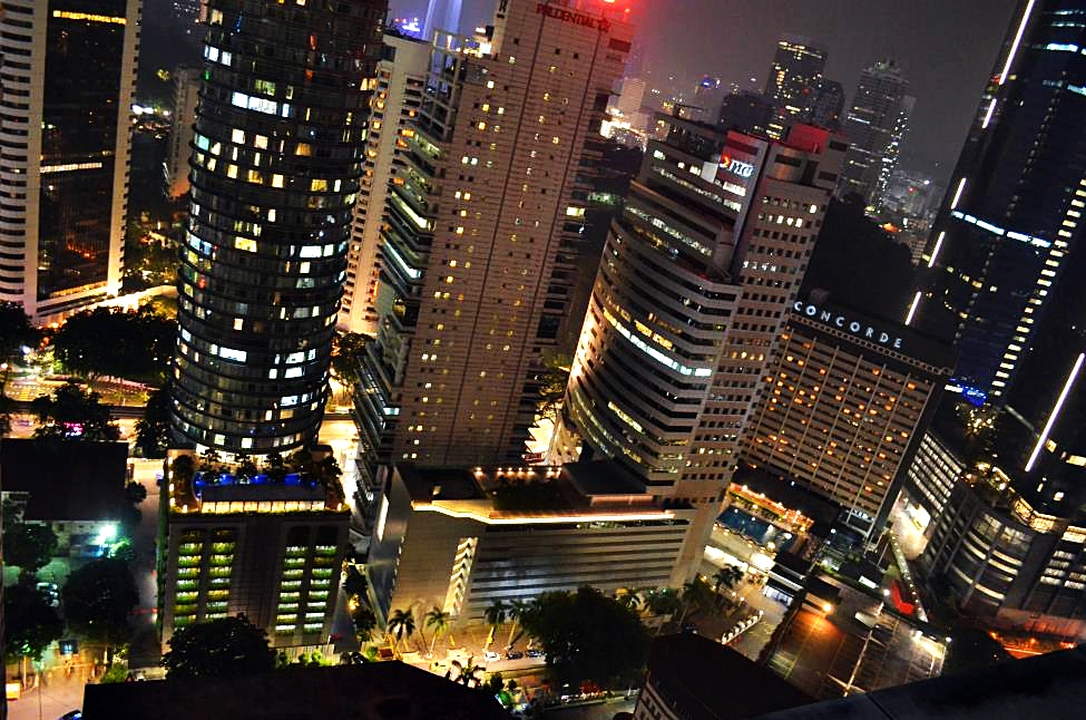 Overlooking Kuala Lumpur downtown from the rooftop terrace with evening lit up buildings
