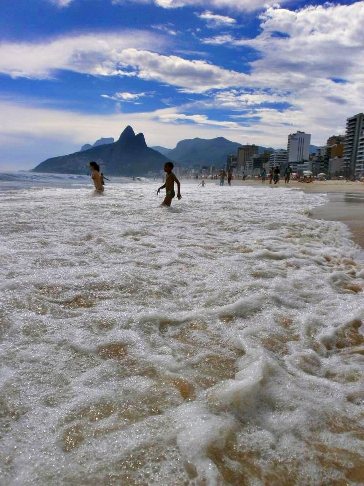 Wave washed Ipanema beach with locals getting into the water