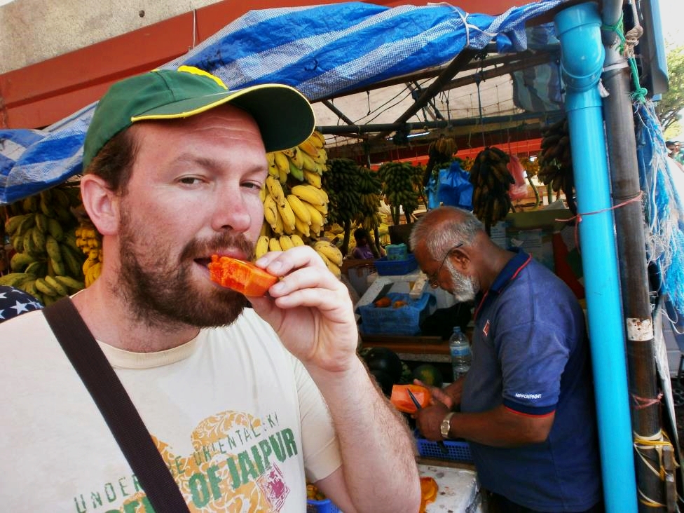Authentic papaya bite. Jonnie is tasting papaya at the local stand