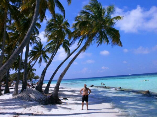 Proudly conquered Maafushi island beach. I am standing on a white sand, next to palm trees and the ocean