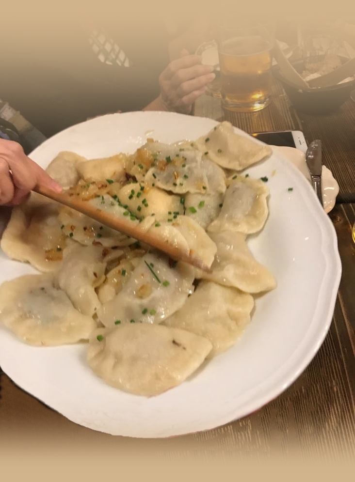 Tasty pierogi on the plate covered with onions and parsley