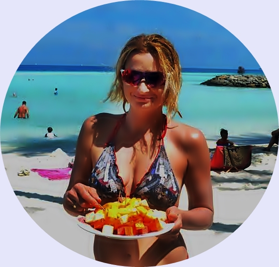 Co-Founder of Jonnie World Walker ready for an exotic salad on Maafushi Island, Maldives. She is holding a plate full of colorful fruits with a beach in the background
