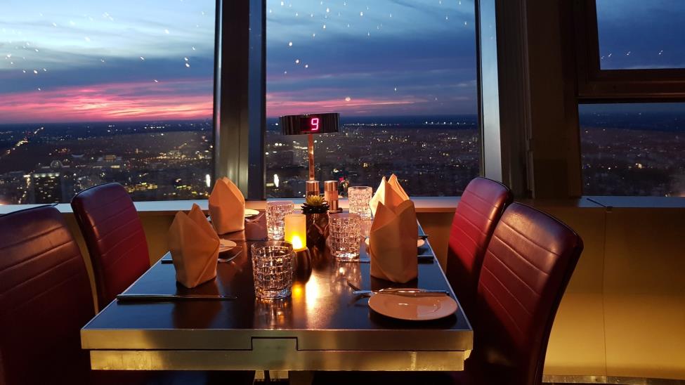 Berlin TV Tower dinner table with purple chairs, elegant setting and a city panorama behind